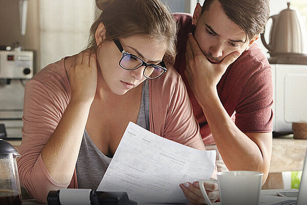 Two individuals looking at a energy bill