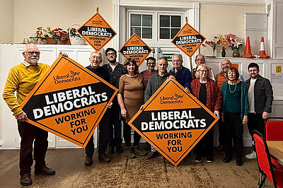Some lib dem members gathered behind Greg Broadhurst showing support for him holding Lib Dem posters